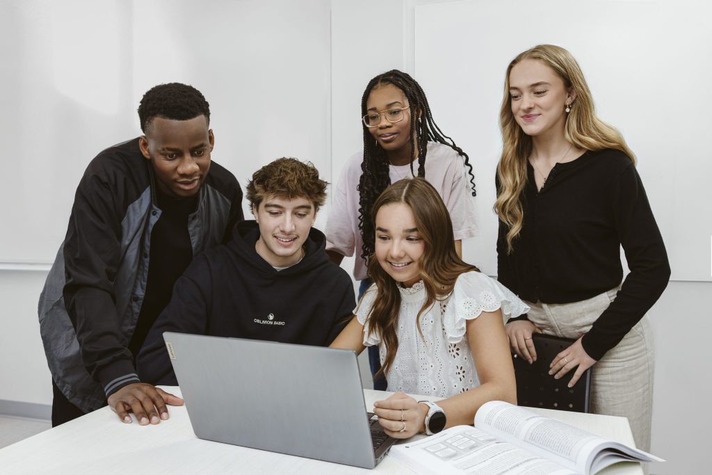 Groupe de cinq étudiants devant un portable